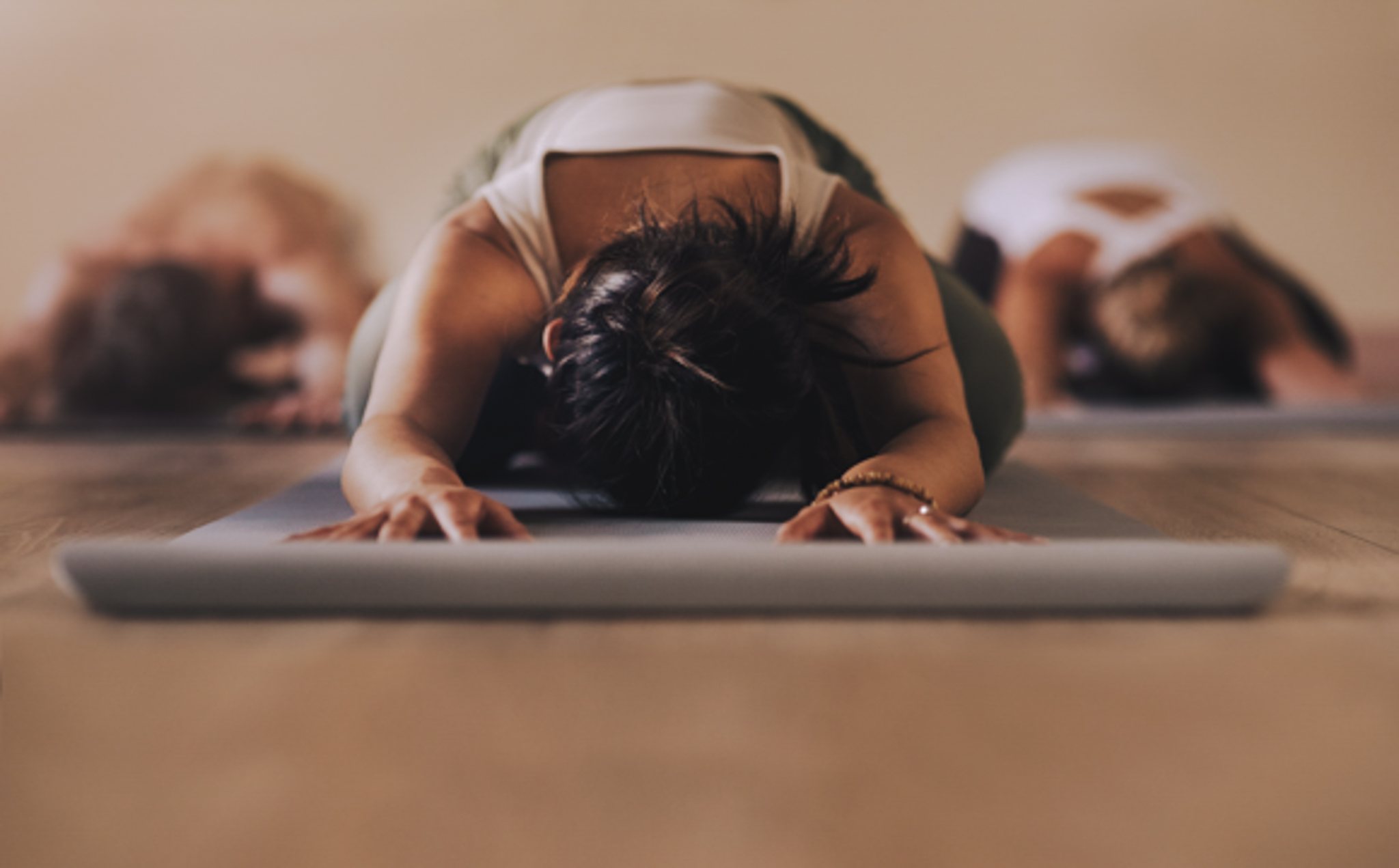 Woman in a plank position on a gym floor exercise mat, indoors
