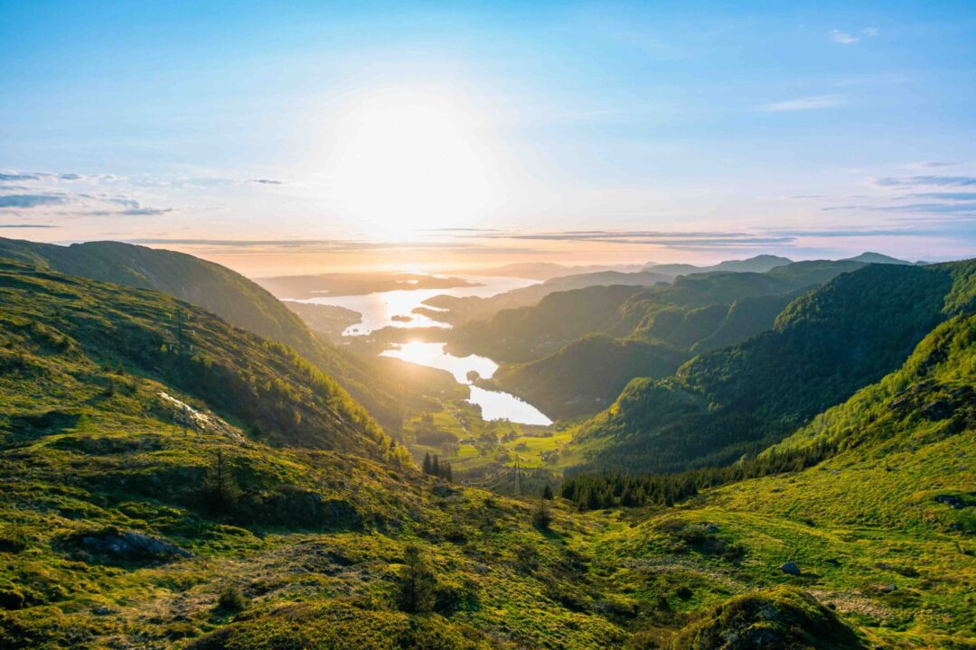 Sunlit Arctic valley landscape at midnight sun, winding rivers and green hills at dusk