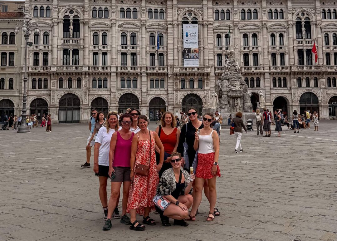 Group of women posing in a European square in front of an ornate historic building