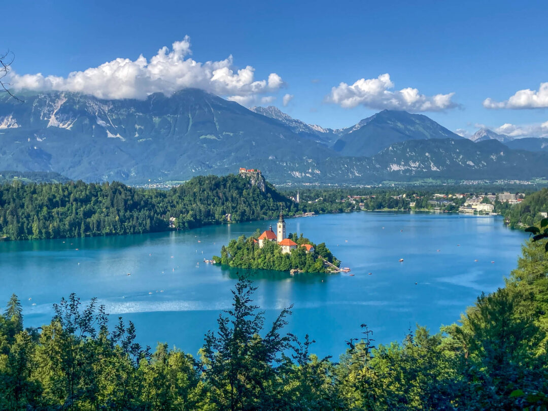Scenic view of Lake Bled, Slovenia, with an island church and surrounding mountains across the lake.