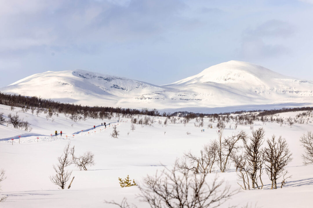 Cross-country skiing on a snowy trail through a winter valley with mountains in Sweden