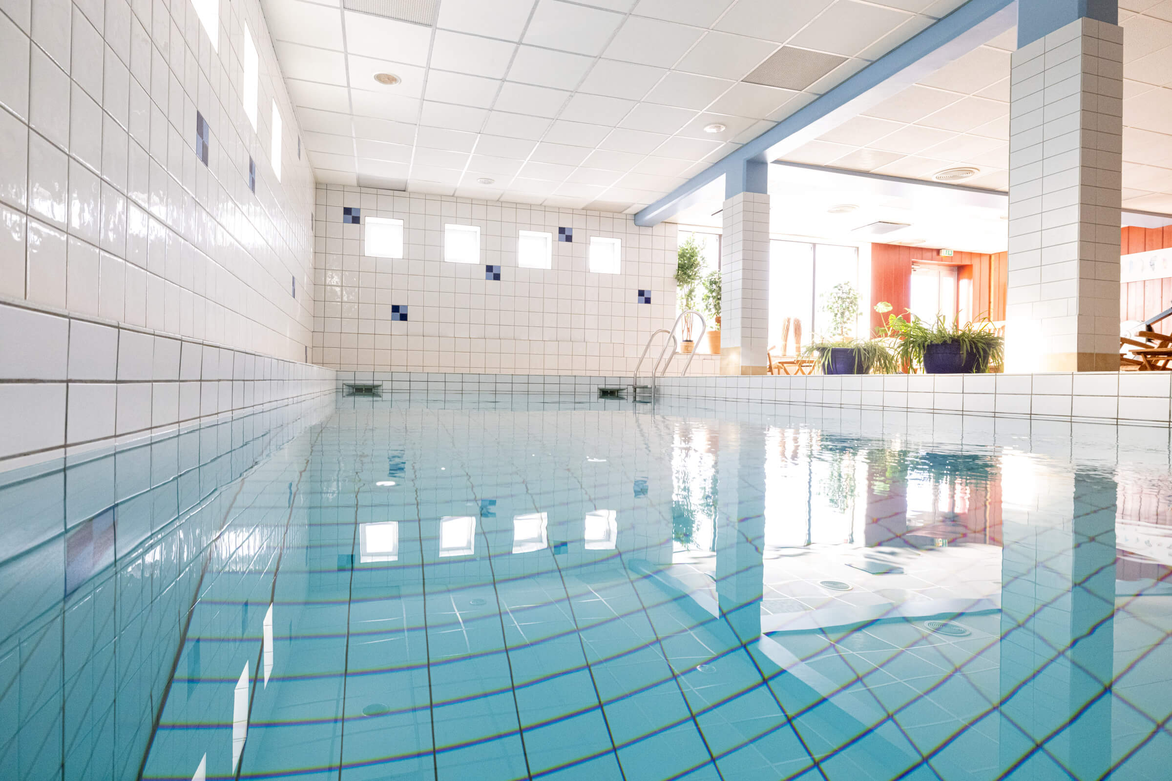 Indoor spa swimming pool with tiled walls and overhead lighting at a Swedish resort hotel in Bruksvallsliden