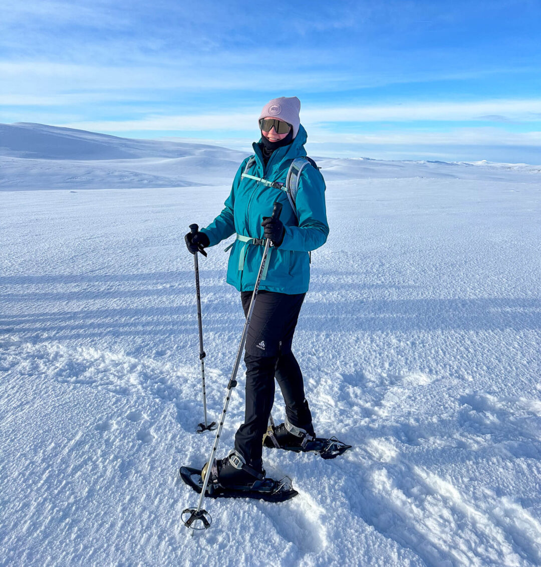 woman snowshoeing in snowy landscape.