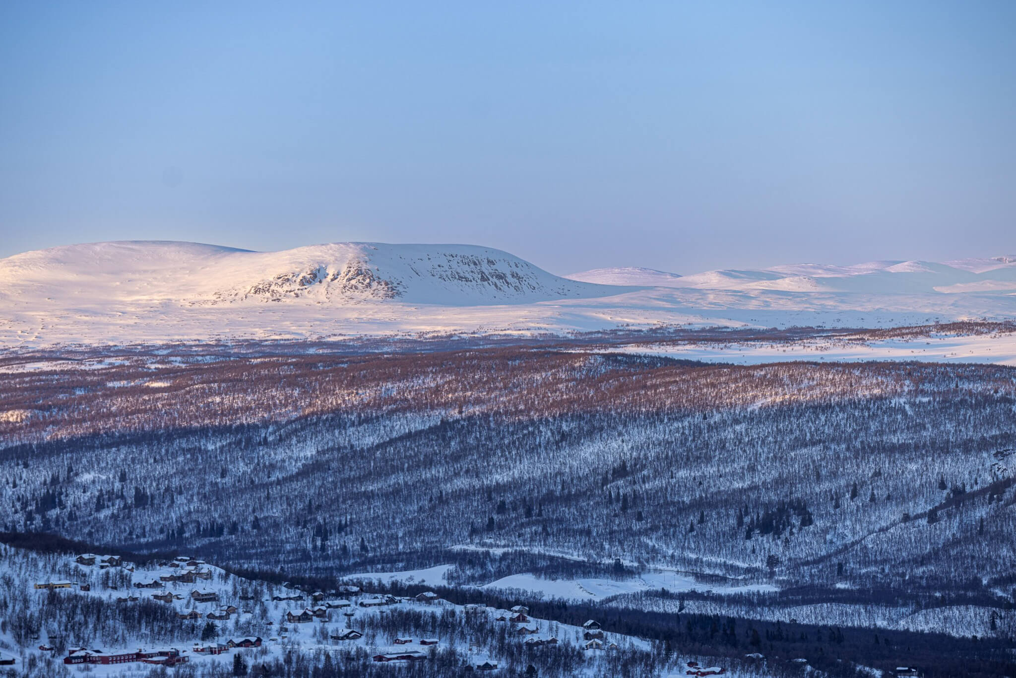 Snowy Swedish mountains at sunrise, wide cross-country ski landscape with valleys under a clear winter sky