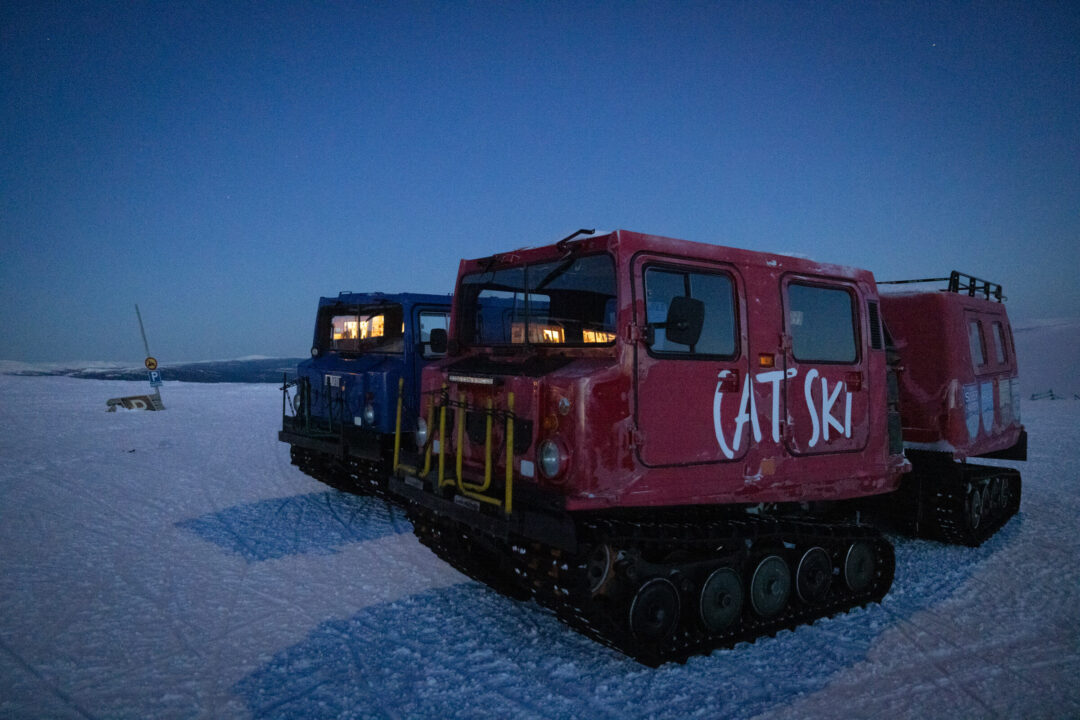 Snow vehicles parked in twilight