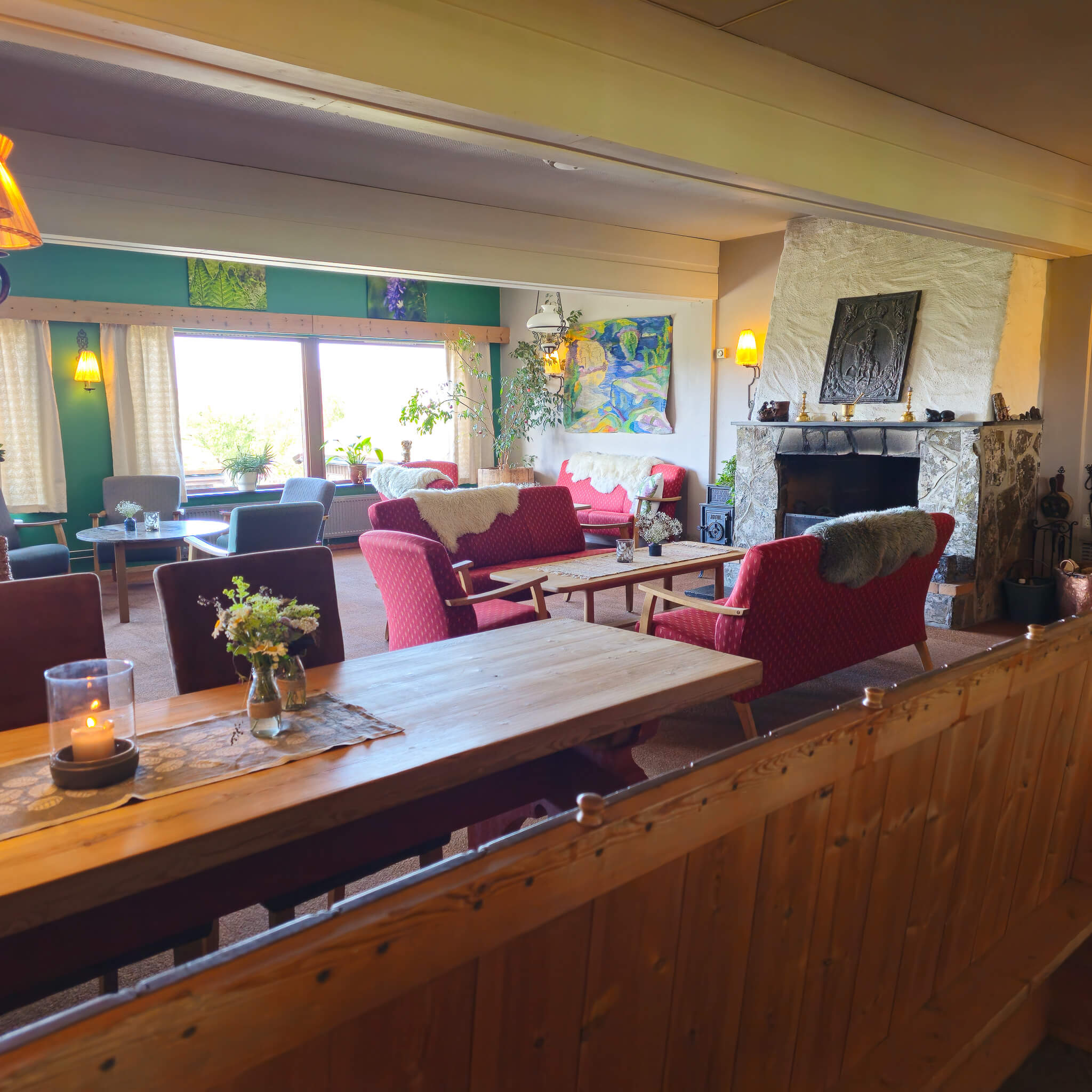 Cozy Norway cabin living room with fireplace, armchairs and warm light for a cross country ski and yoga stay