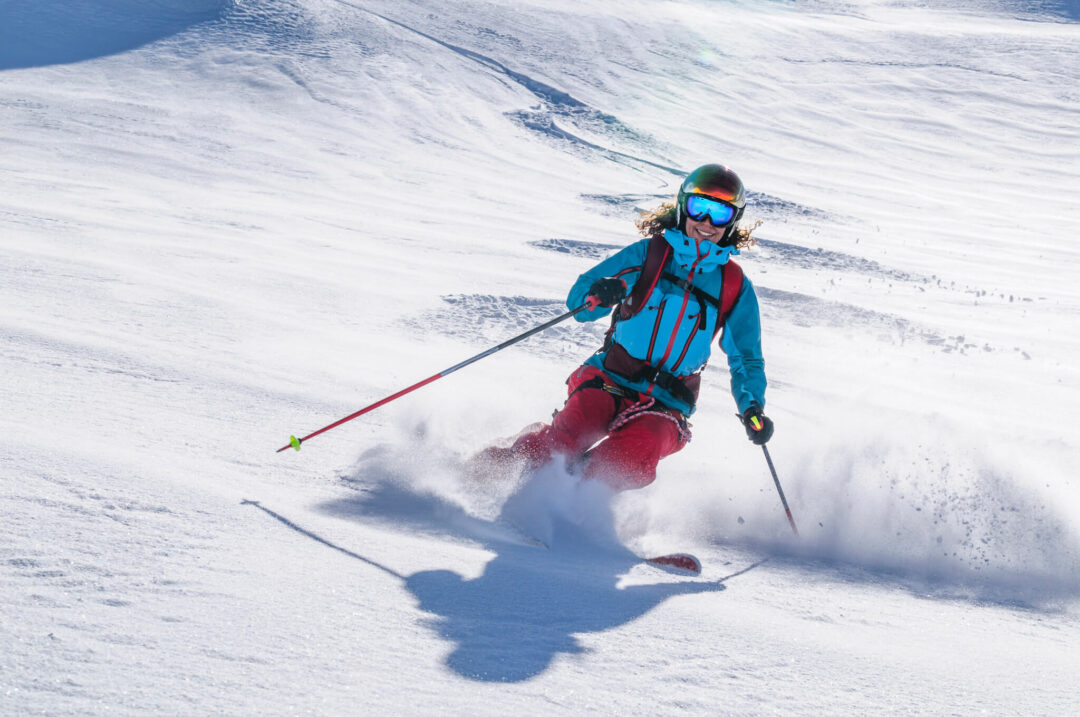 Ski touring skier carving fresh powder on snowy Swedish mountains