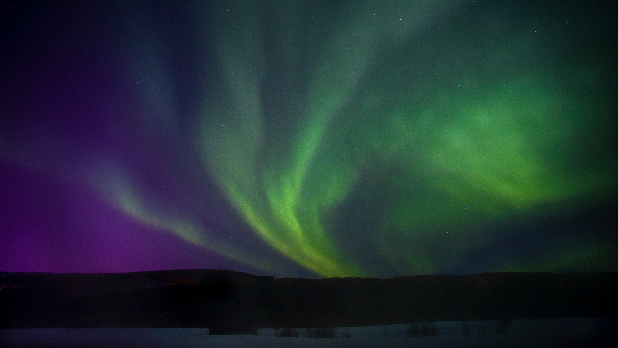 Northern lights aurora over a snowy landscape, ideal for a Norway cross-country ski and yoga holiday