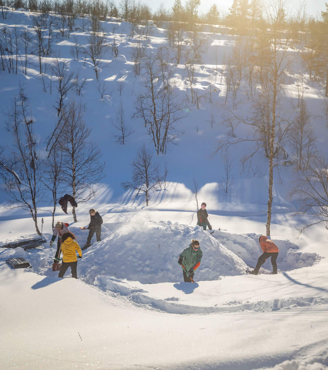 Backcountry skiers trek through snowy Lapland forest on a hut-to-hut ski expedition