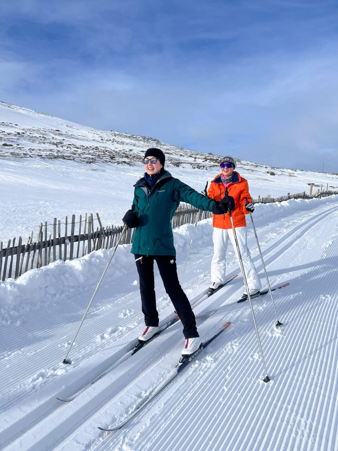 Two winter skiers cross-country on a snowy trail in North Iceland, enjoying multi-activity holiday.