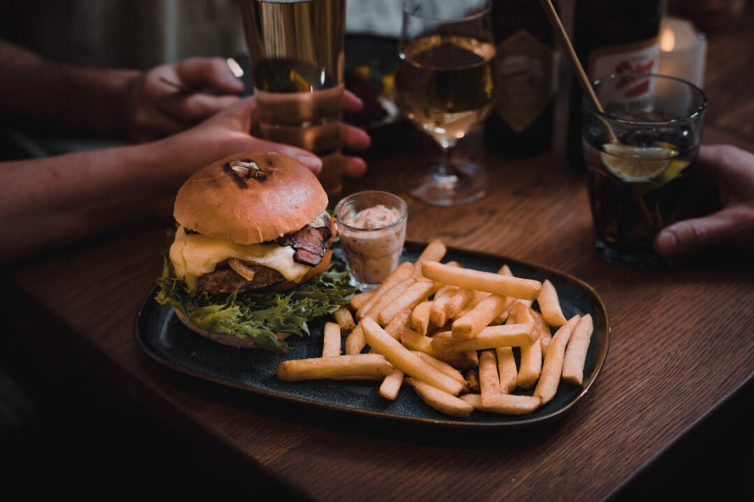 Ski-friendly après-ski burger and fries with drinks shared at a Swedish lodge table