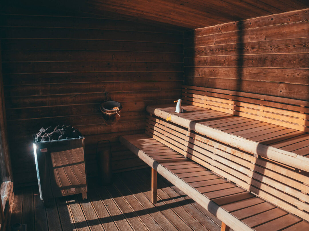 Sauna interior with wooden benches, bucket and ladle in a cabin in Lofoten