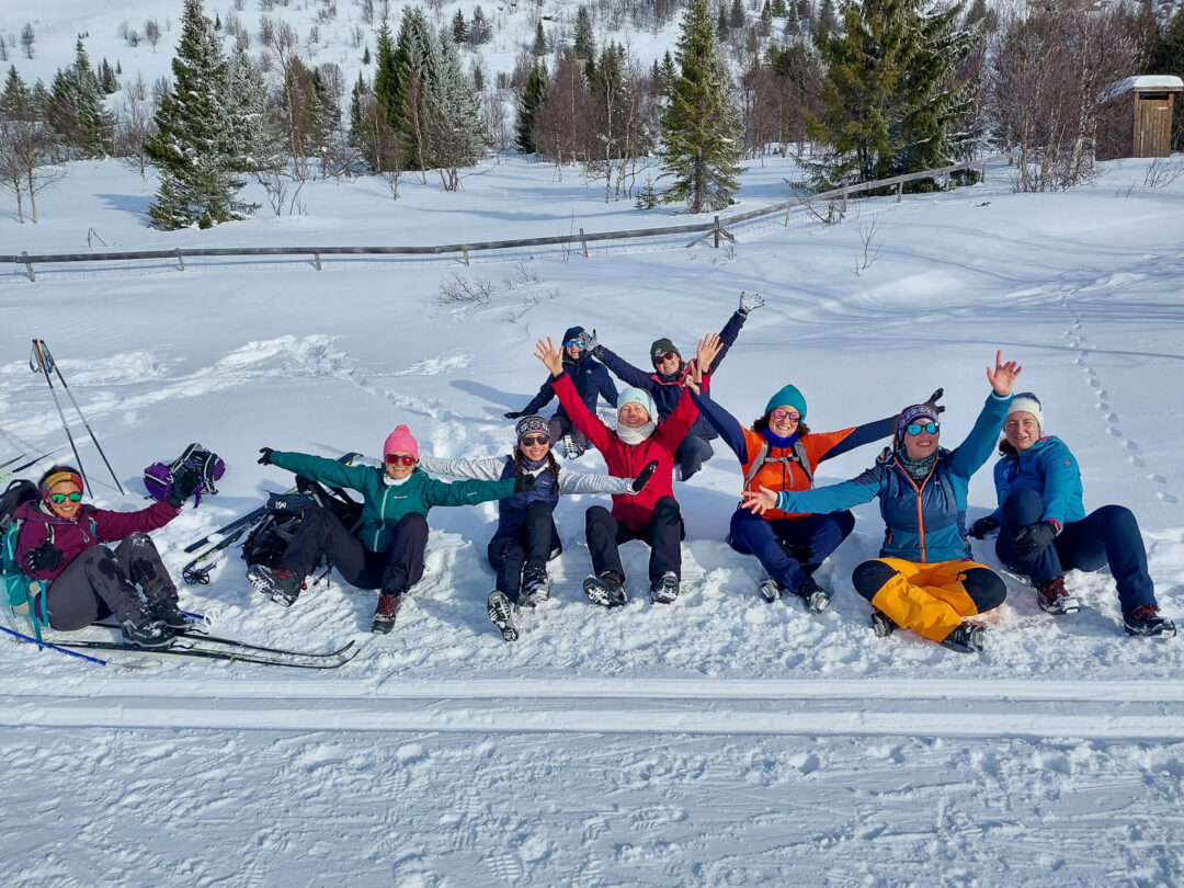 Beginner cross-country skiers cheering in the snow on a Norway trail during a ski and yoga holiday