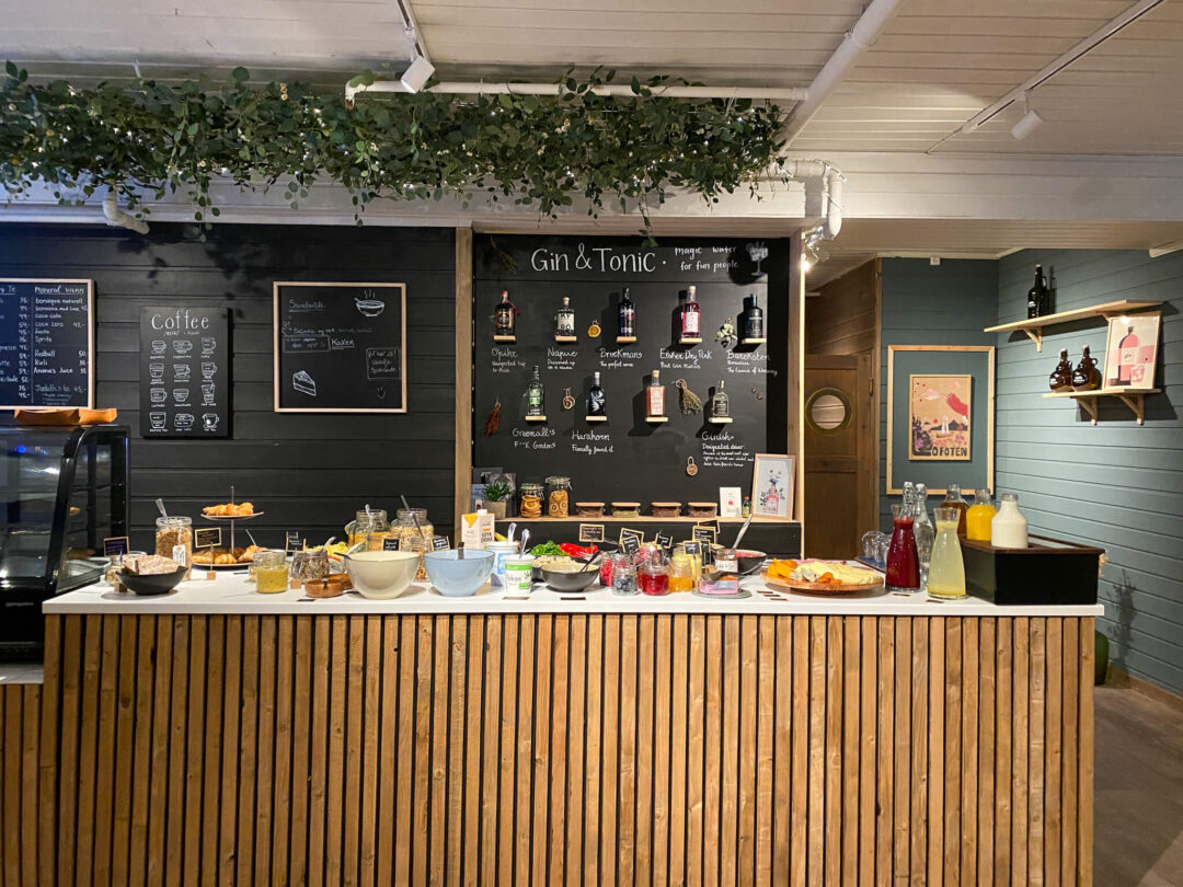 Gin & Tonic bar counter with chalkboard menu and bottles inside a venue.
