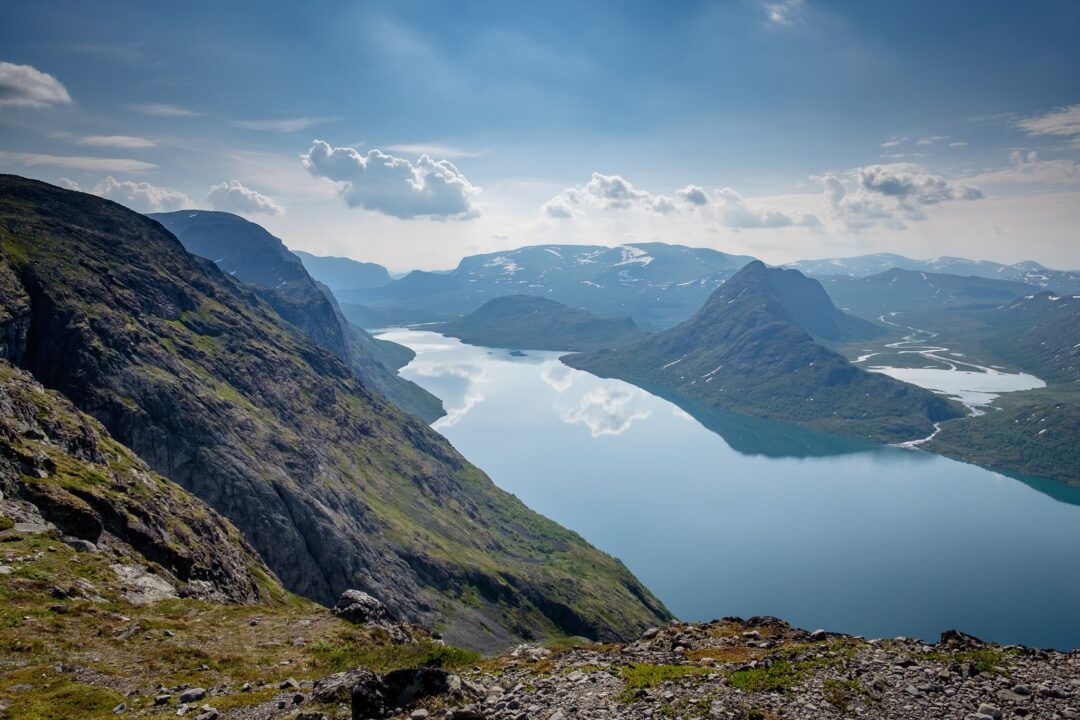 Norwegian mountain hiking viewpoint overlooking fjords and a turquoise bay under dramatic clouds