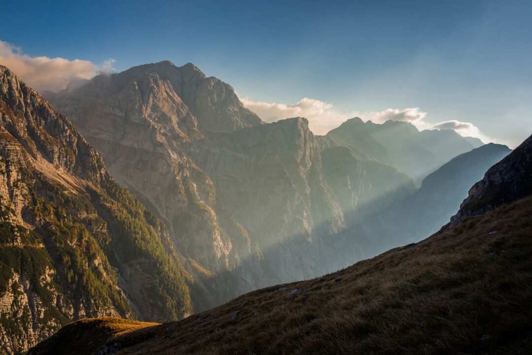 Mountain hiking viewpoint over a misty valley and rugged ridgeline at sunrise