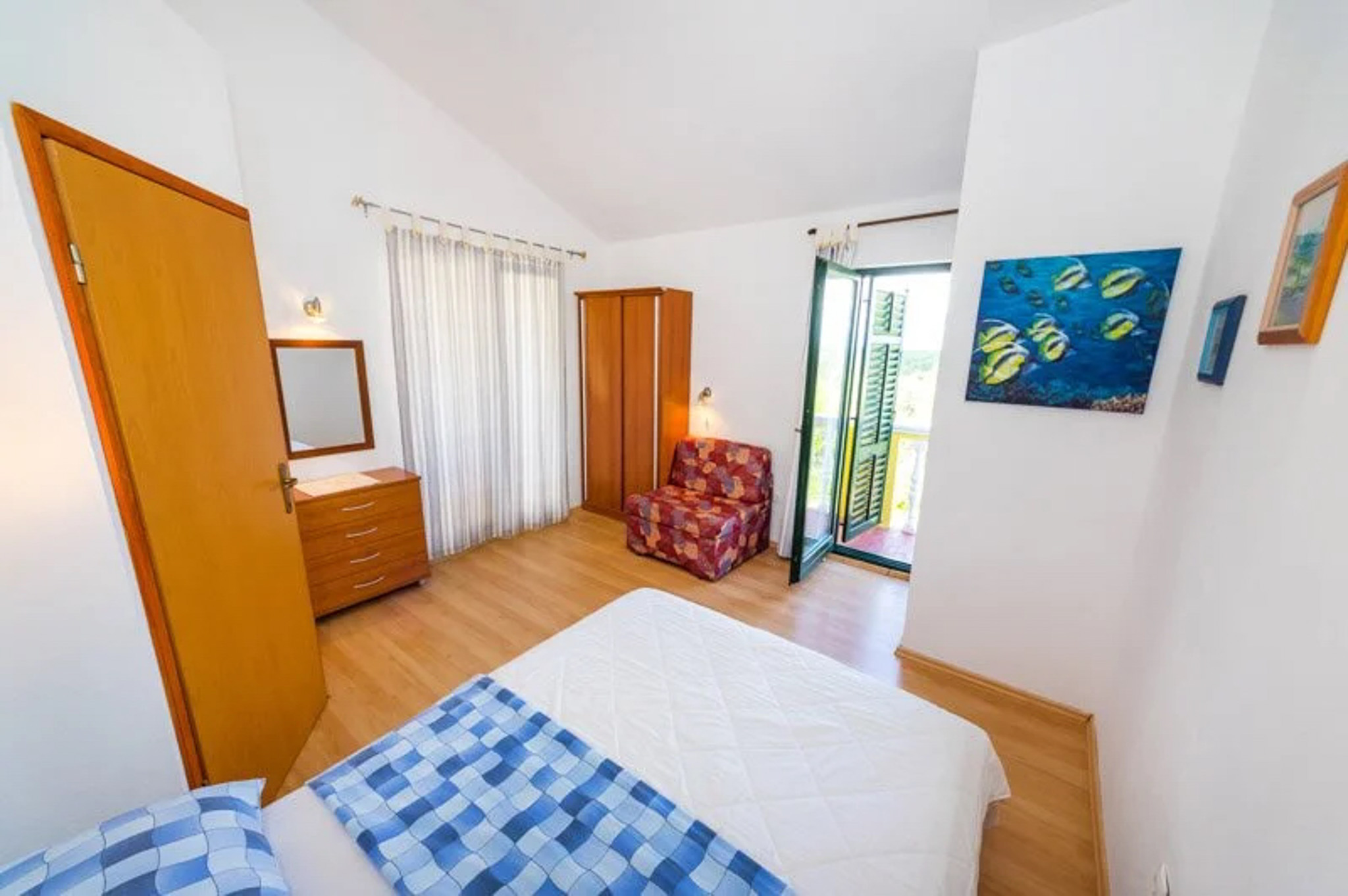 Bright double bedroom interior with bed, wardrobe and open door, likely for a stay in Croatia
