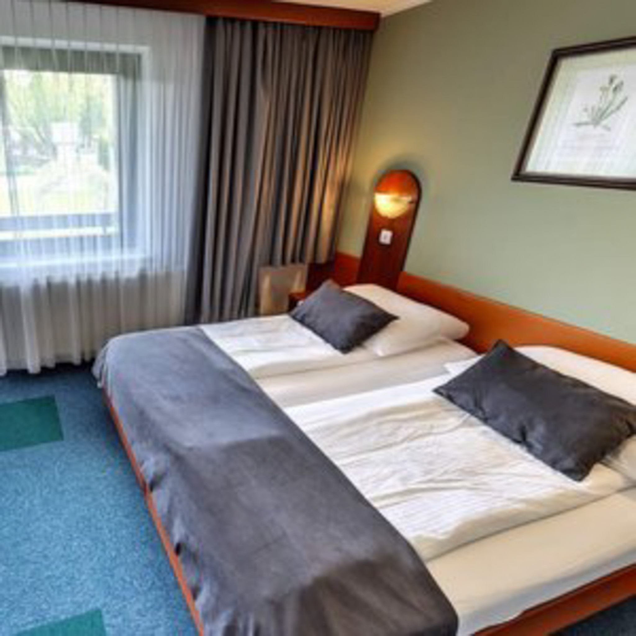 Double hotel room with two single beds and bedside lamps
