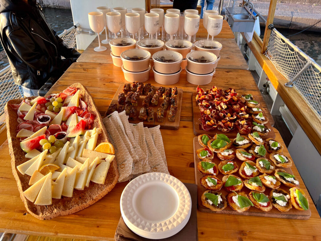 Wooden boat table laid with pizzas, antipasto platters and coffee cups
