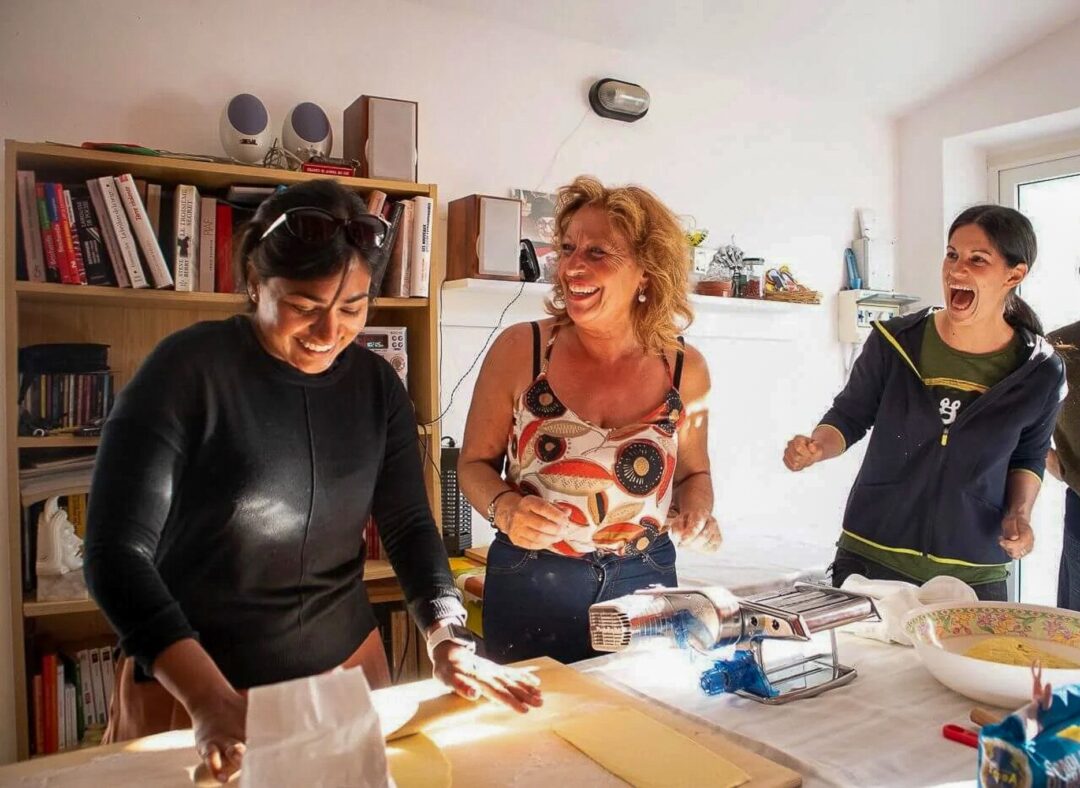 Women sewing with a sewing machine in a workshop, preparing fabric projects