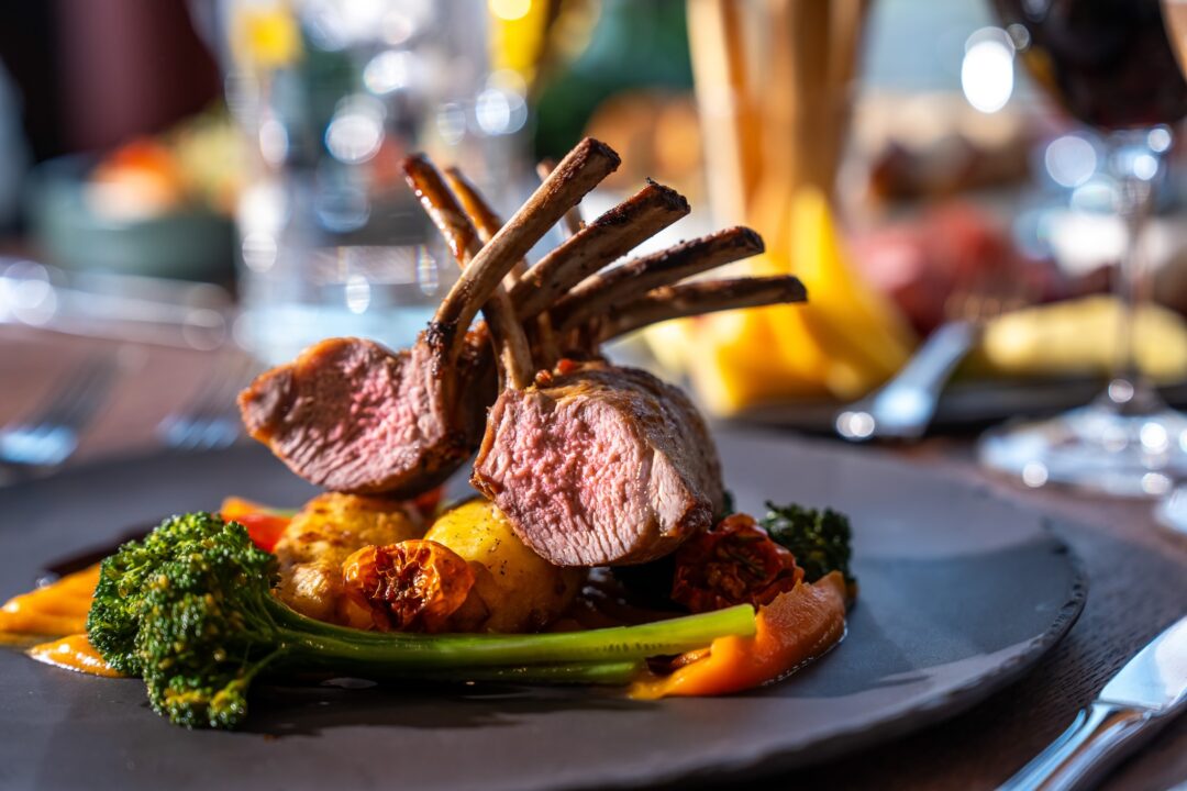 Rack of lamb chops served with vegetables on a restaurant plate