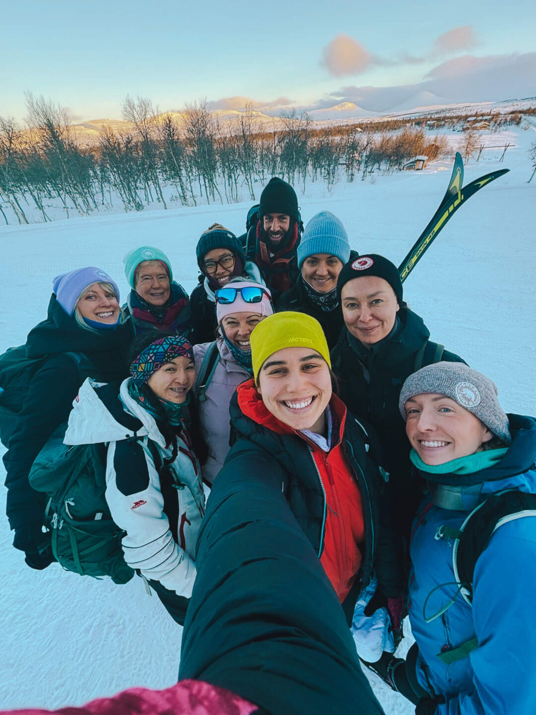 Women on a cross-country ski holiday in snowy Norway, posing outdoors with skis and goggles.