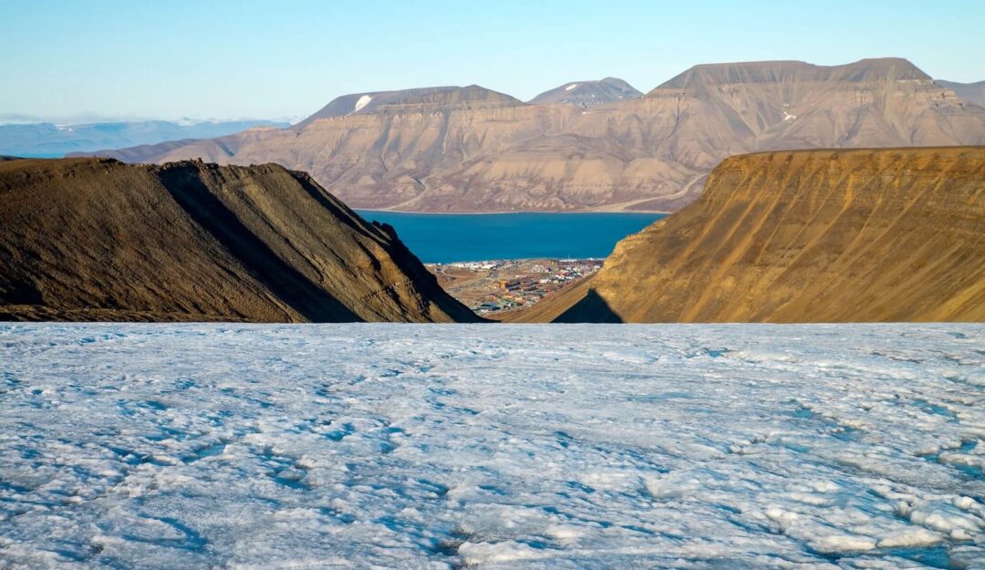 Glacier ice in the foreground with Arctic mountains and sea in Svalbard summer wilderness landscape
