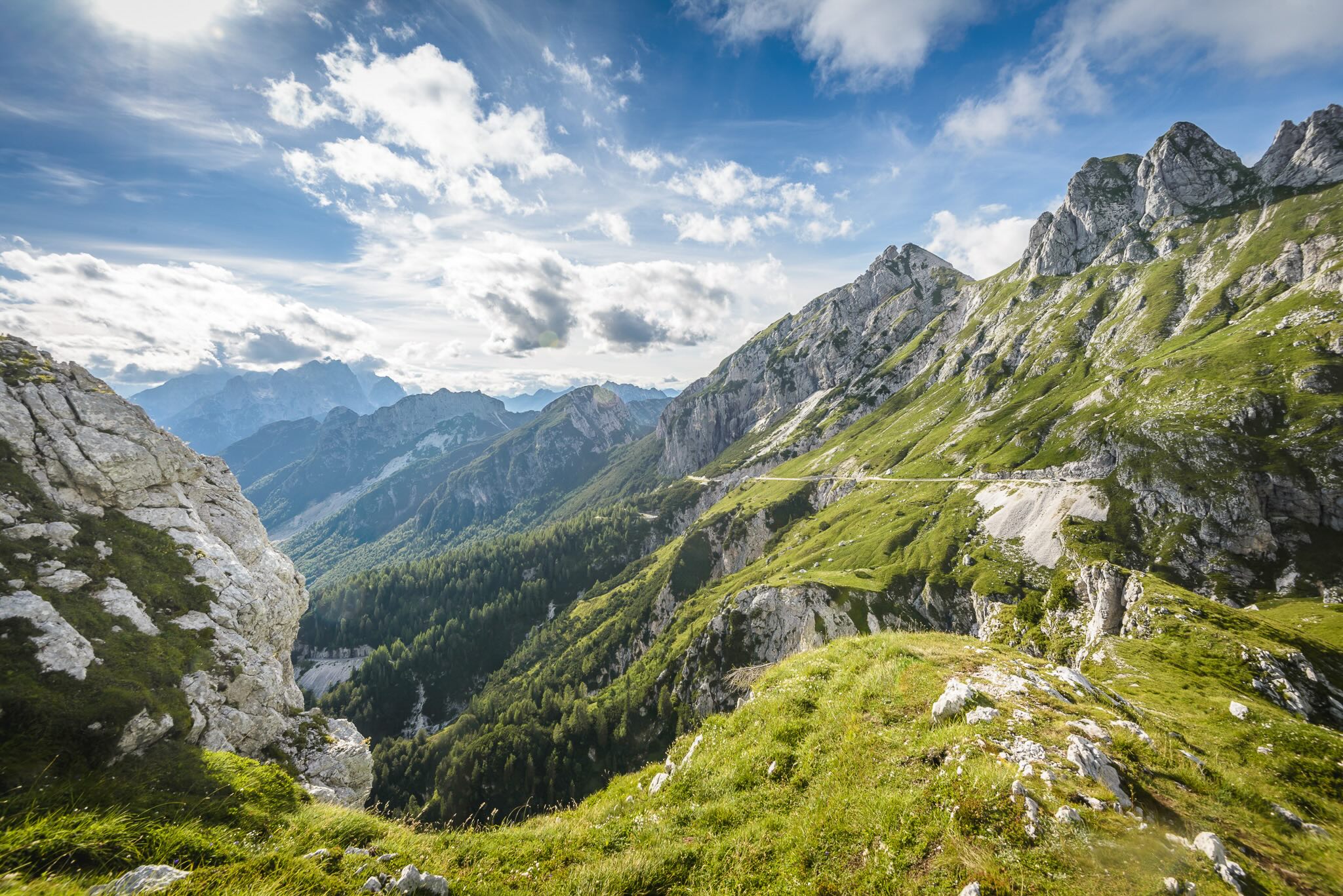 Alpine mountain landscape with lush green slopes, rocky peaks and a wide valley view for hiking