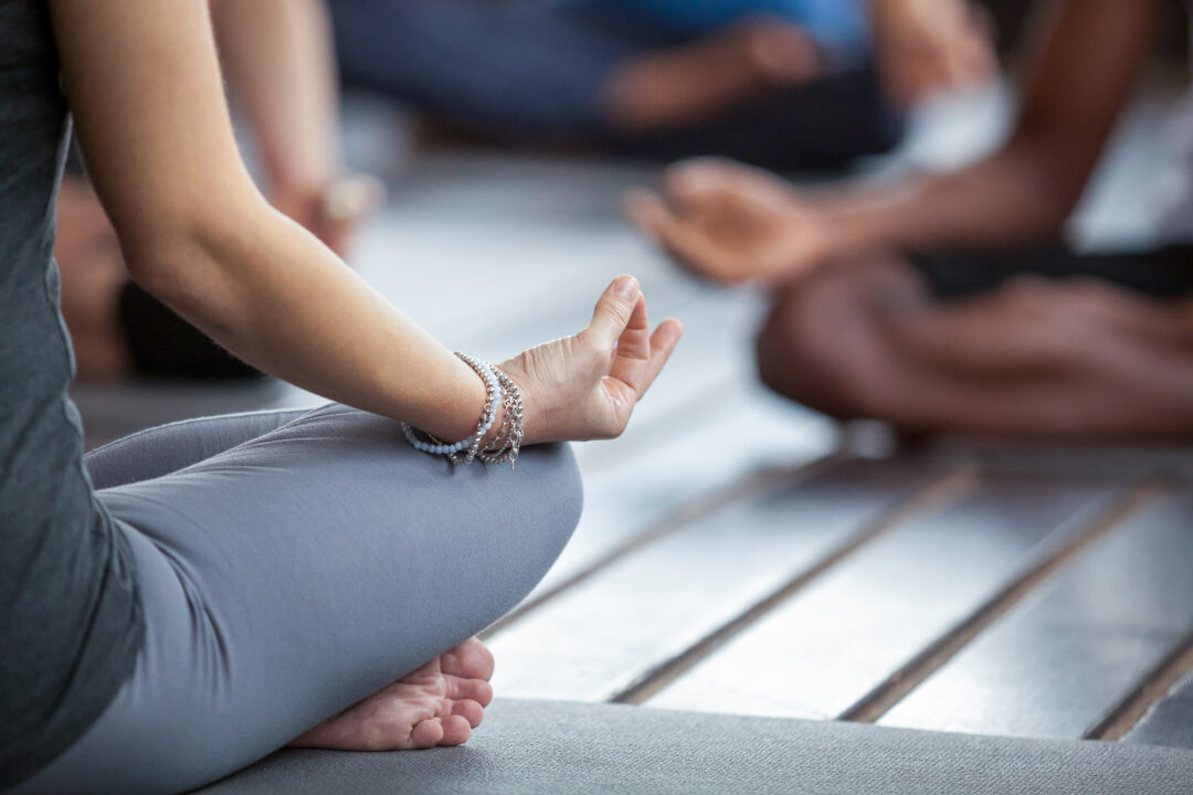 Woman stretching in yoga on a mat during an outdoor hiking holiday in Norway