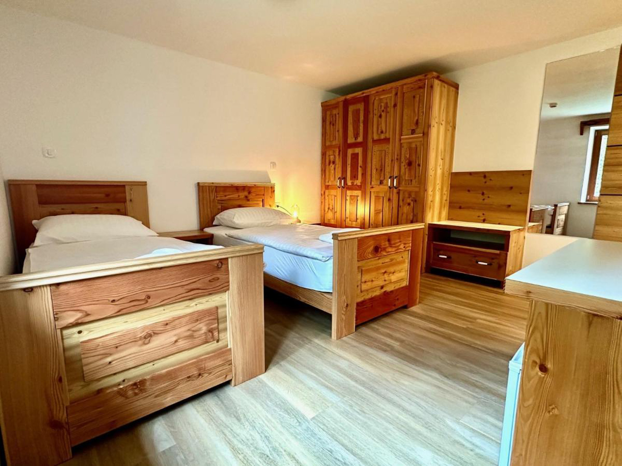 Wooden twin bedroom with beds in a Slovenian hut for women’s hut-to-hut hiking adventure