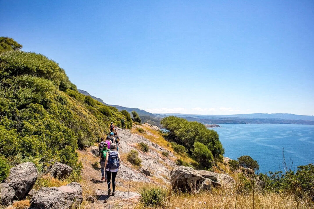 Women hiking along a coastal path with sea views in Sardinia