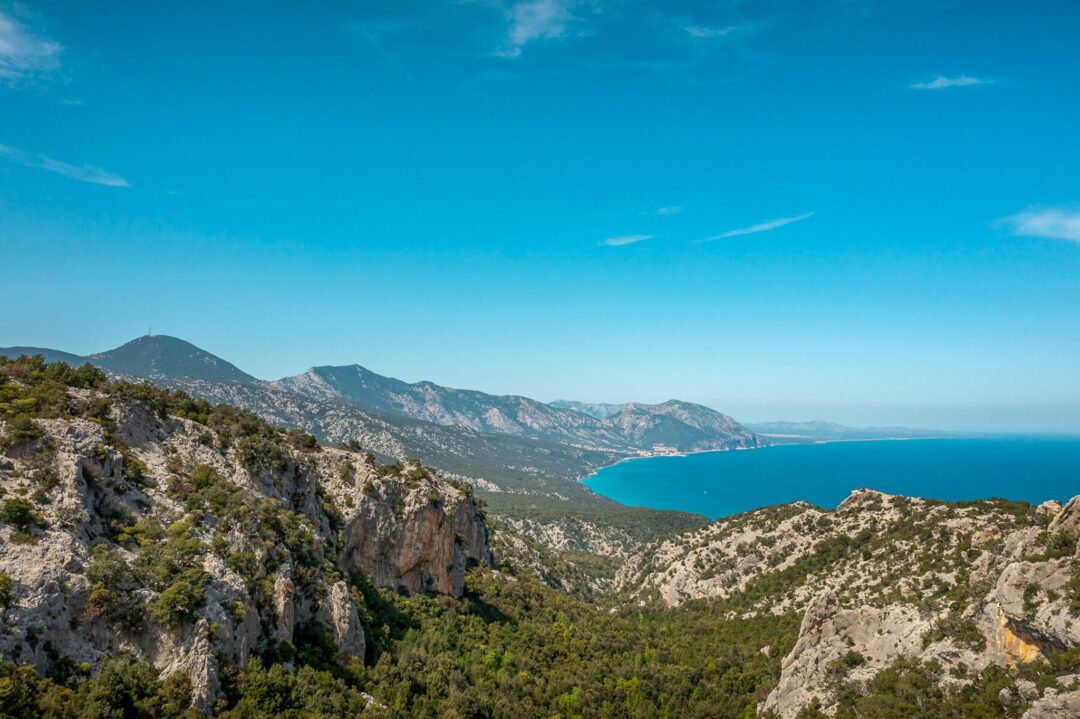 Coastal landscape over East Sardinia with turquoise sea, rugged cliffs and mountain views