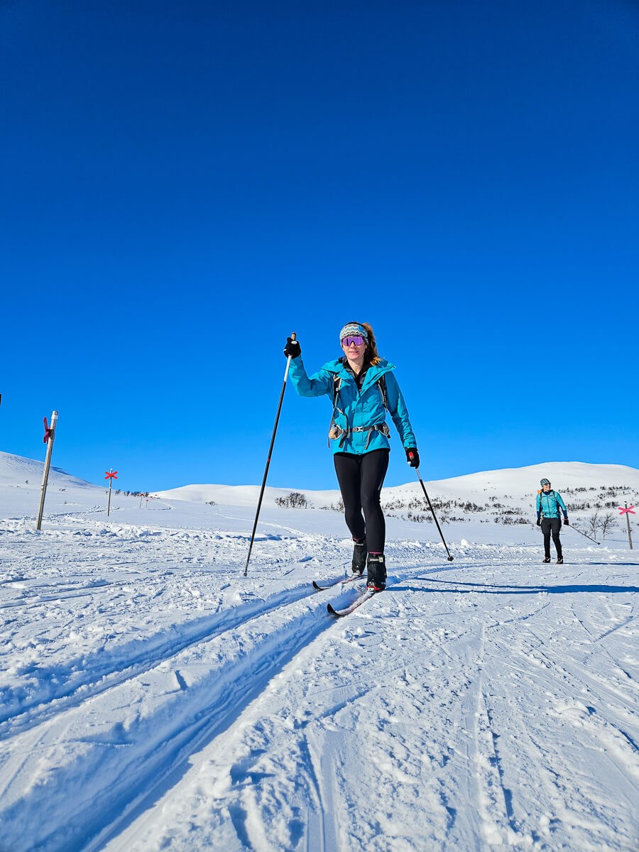 women cross country skiing on snowy landscape.