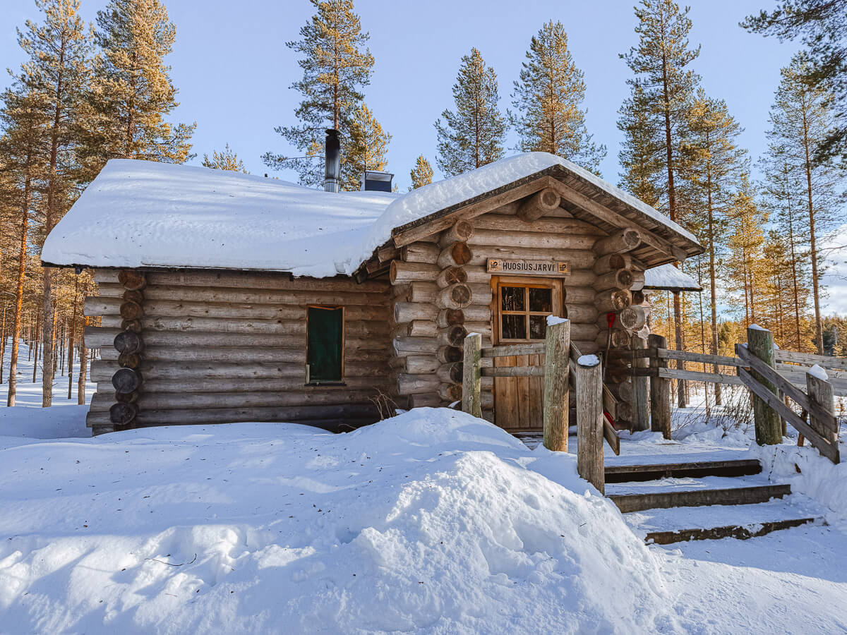 Snow-covered log cabin in a pine forest, Finland