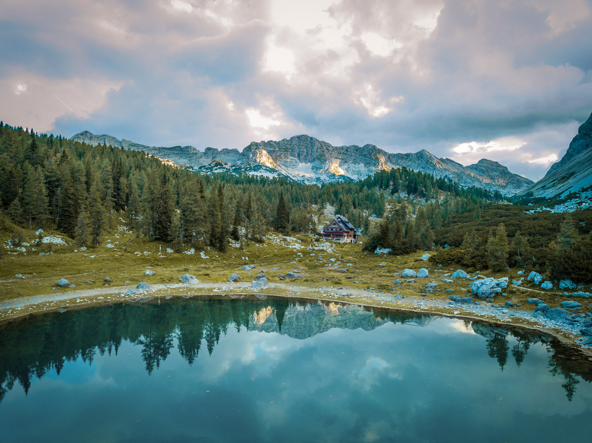 Lake and alpine cabins in Slovenia with mountains, scenic hut-to-hut hiking view