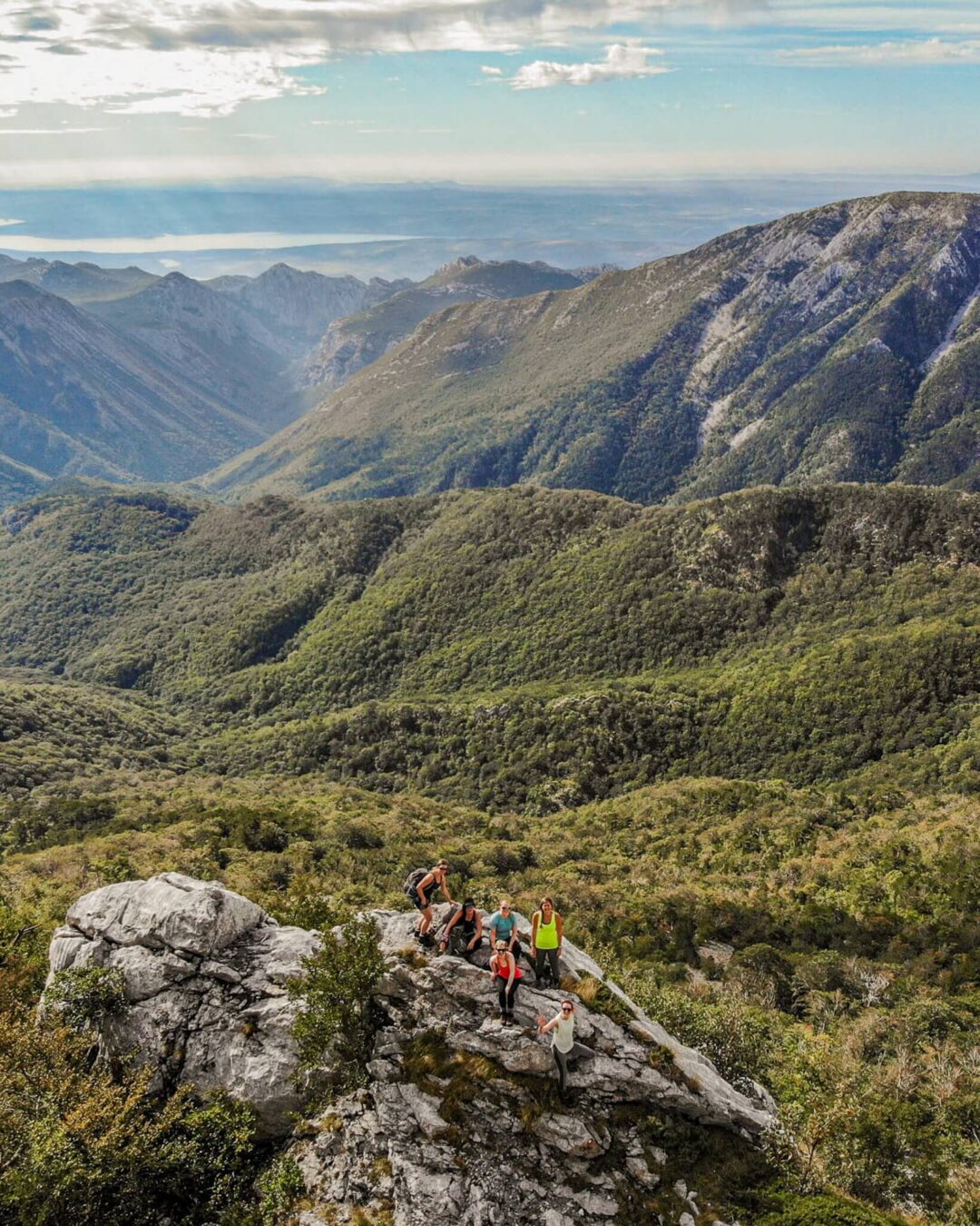 Women hiking on a rocky ridge overlooking mountain valleys in Europe