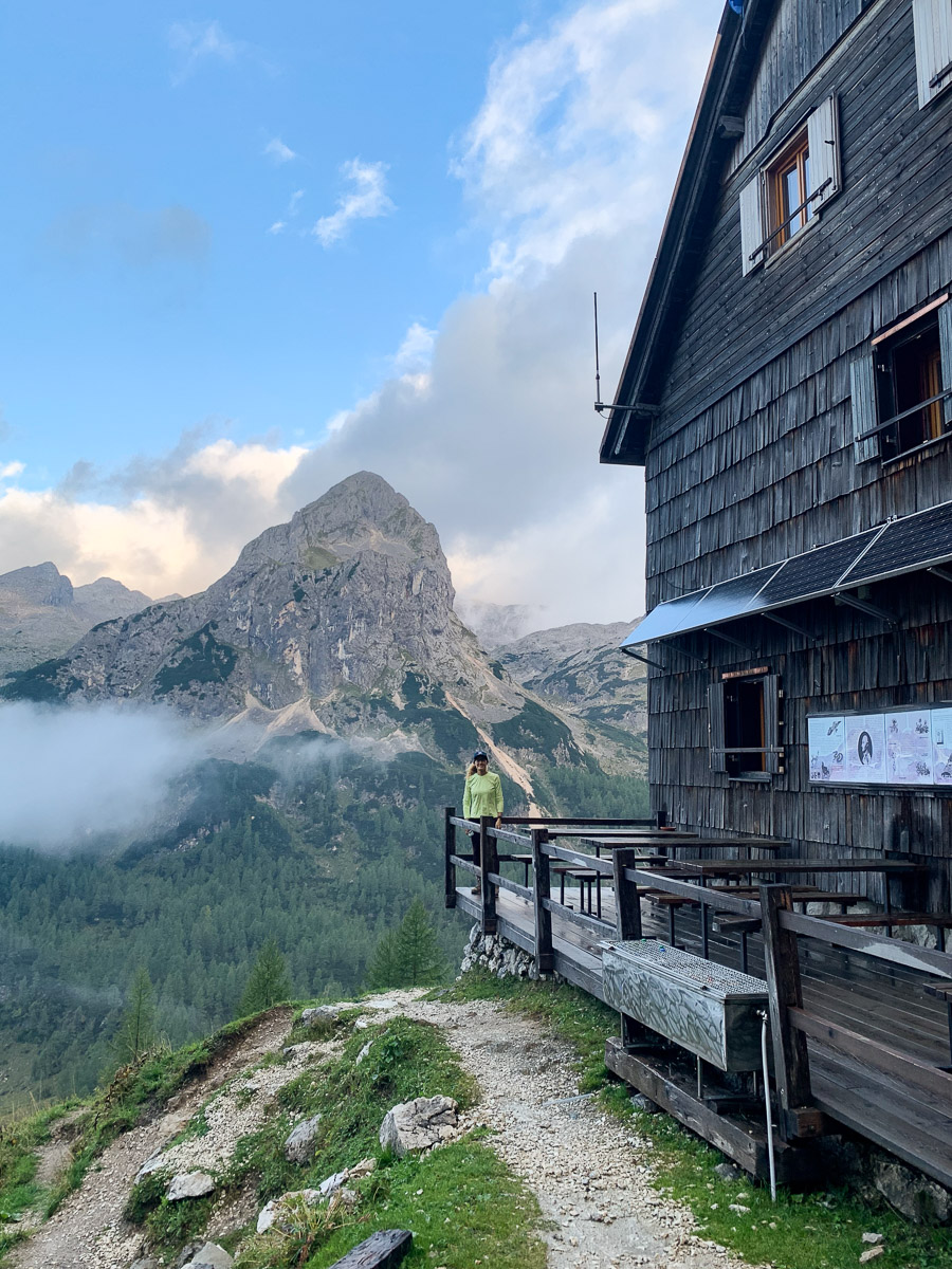 Hut-to-hut hiking route beside a mountain hut with alpine views in Slovenia