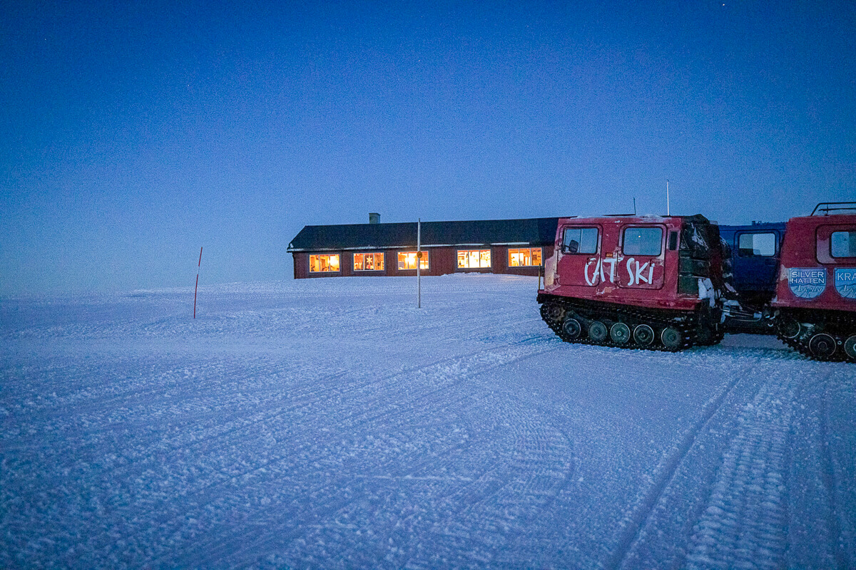 Snowy landscape with lodge and snowcat