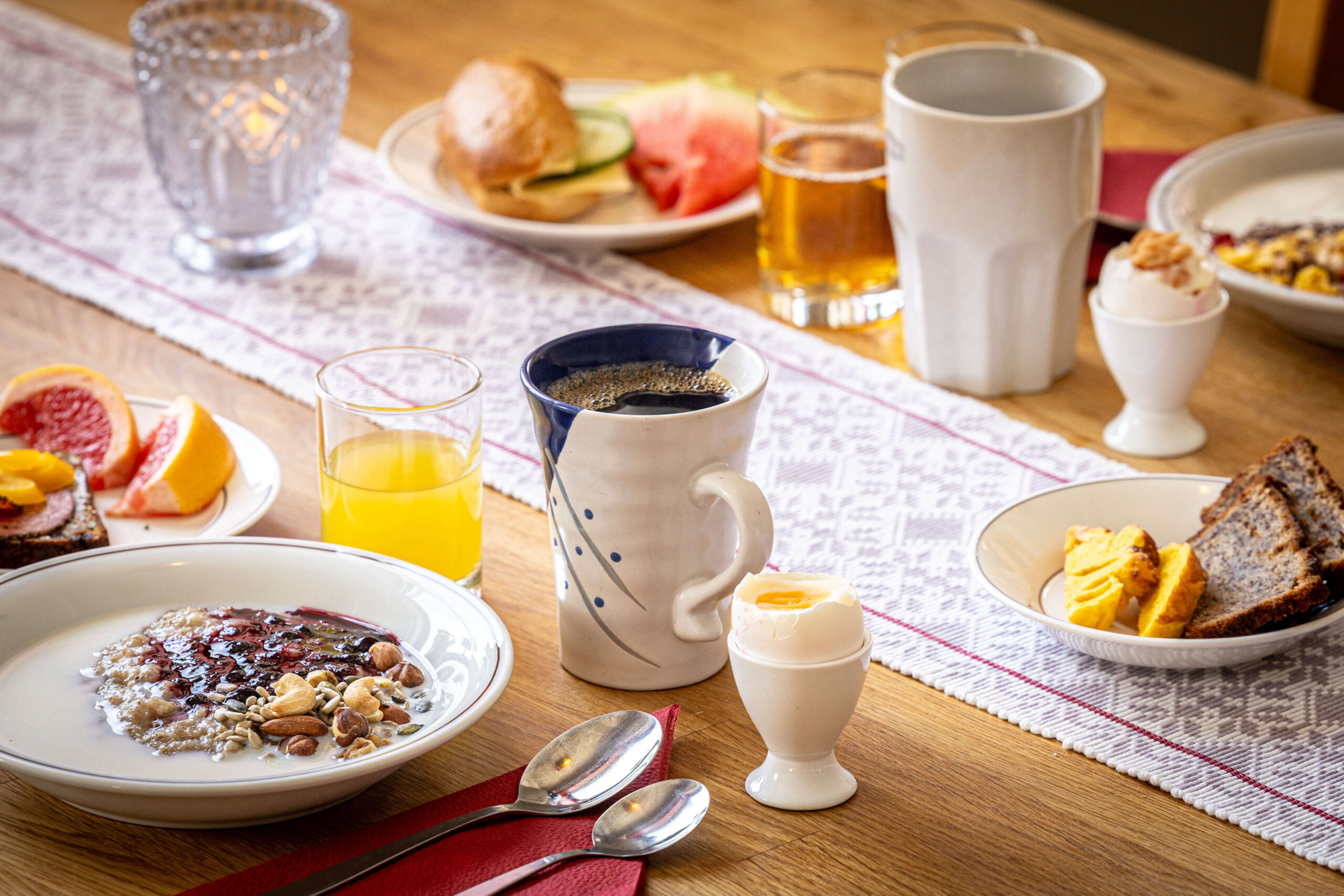 Breakfast table with plates and drinks, including bowls of cereal and tea, indoors in Sweden