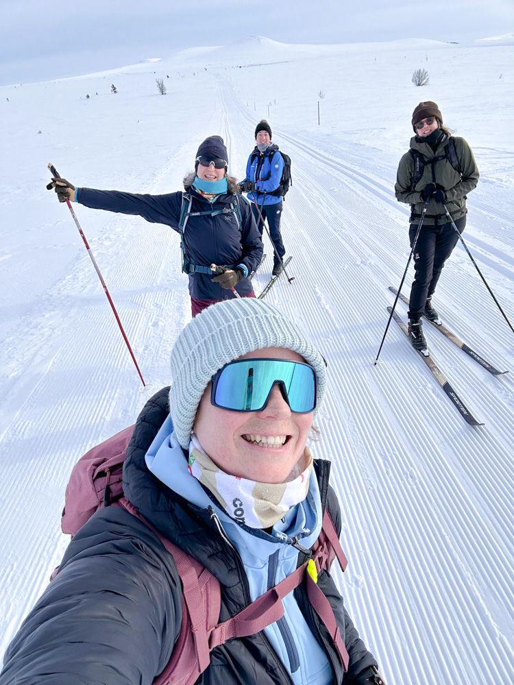 Women cross-country skiing on a snowy track across a winter landscape