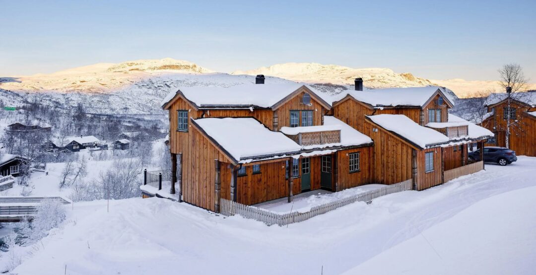 Snowy wooden cabins in winter landscape in Norway