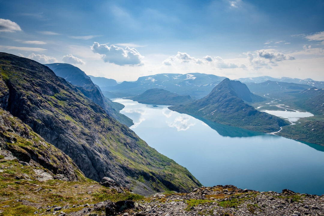 Mountain viewpoint overlooking a fjord and valley under a blue sky in Europe