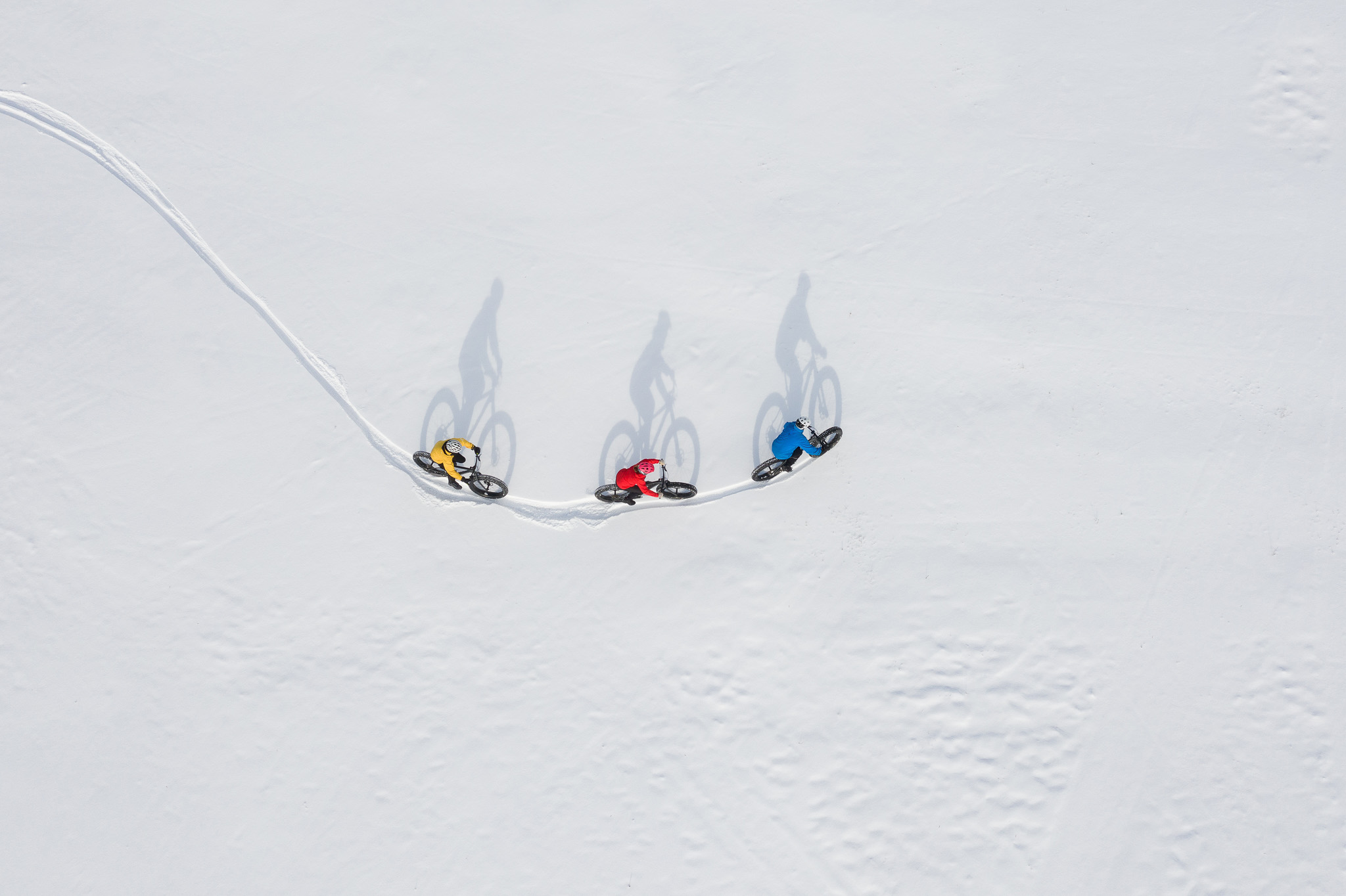 Three women skiing downhill on a snowy slope in Europe