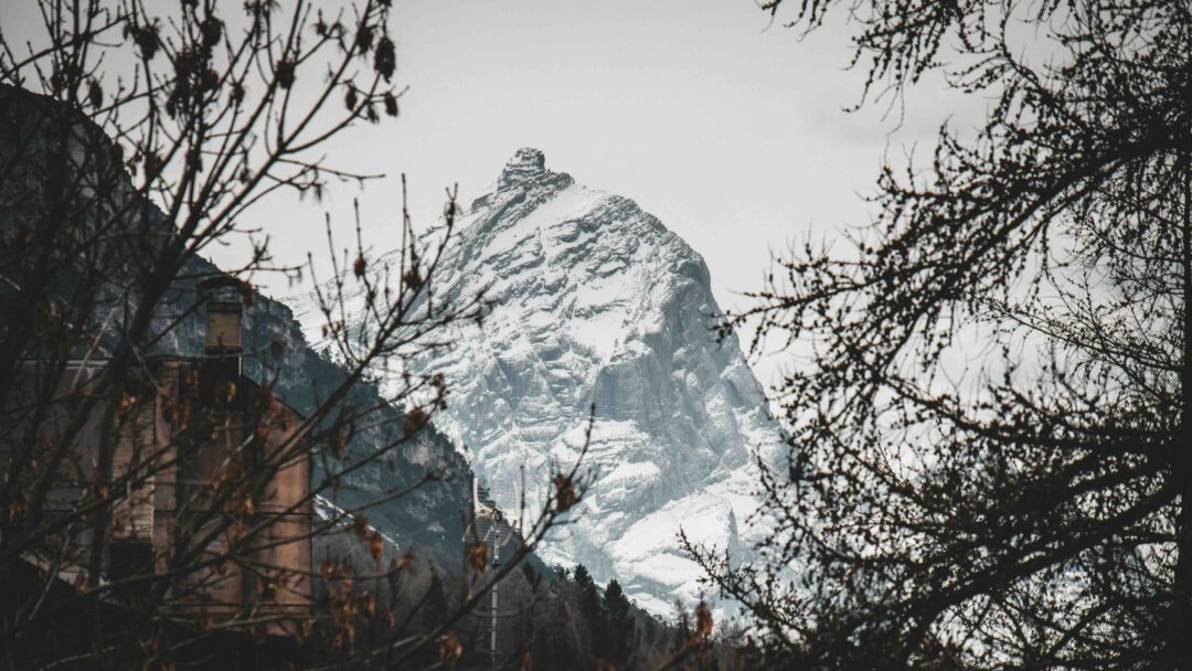 Snowy Dolomites mountain peak with village buildings, suitable for guided snowshoeing holidays