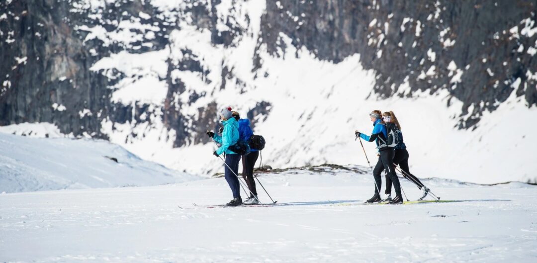 Women cross-country skiing on a snowy trail in snowy mountains