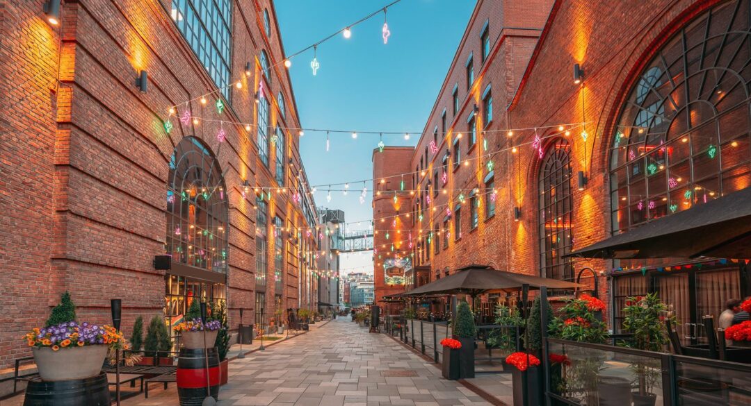 Oslo alley with brick buildings, festive string lights and outdoor café seating