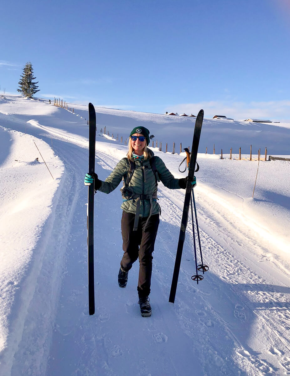 Woman cross-country skiing on a snow-covered trail in a Finnish-style winter landscape