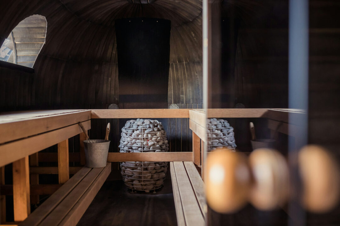 Sauna interior with wooden benches and stacked towels in Oslo lodge