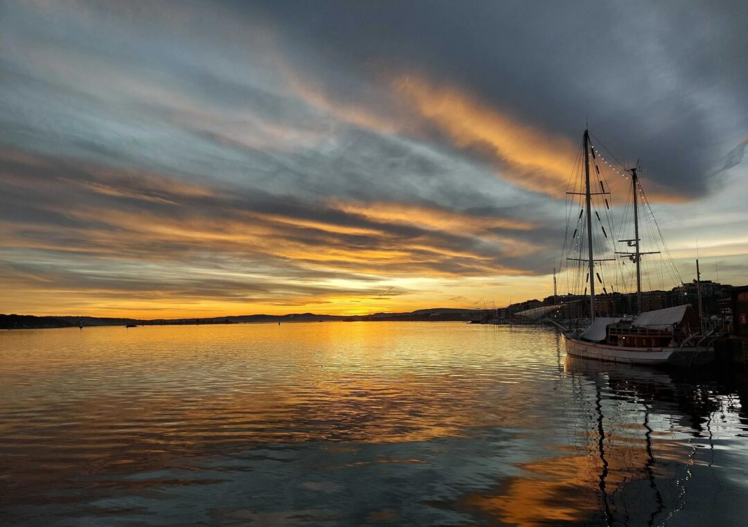 Moored sailing ships at Oslo harbour during sunset