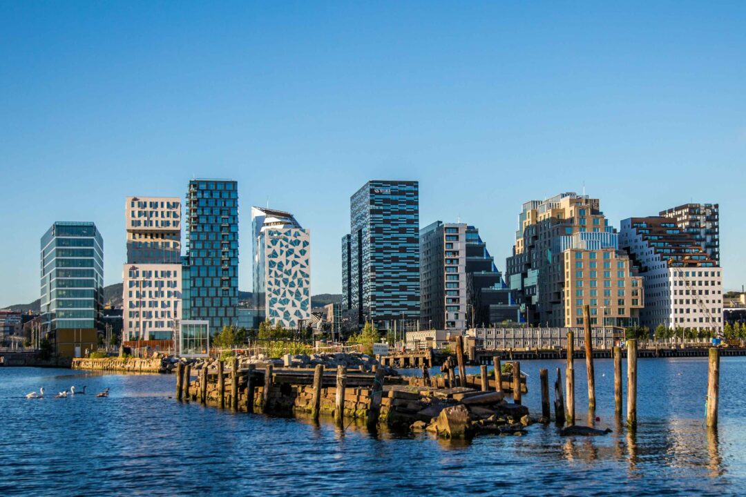 Oslo harbour skyline with a pier and rocks by the water at dusk